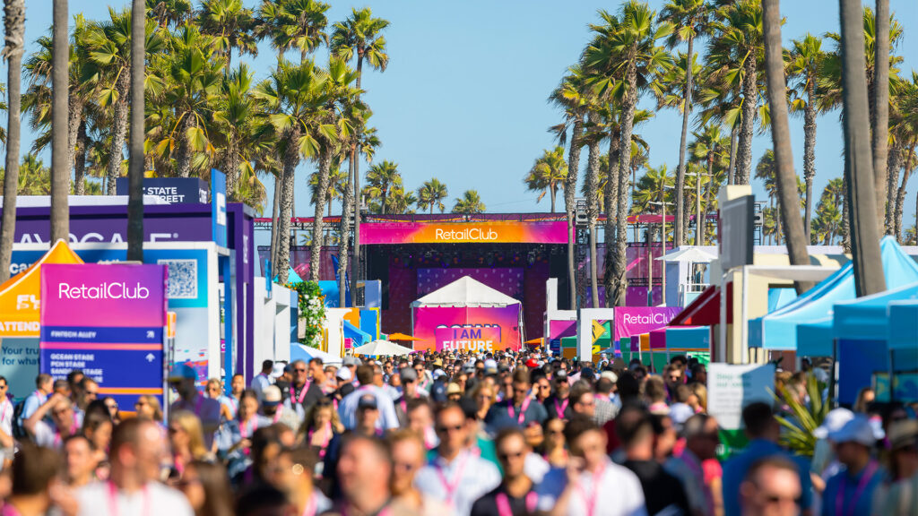 Crowd of people at a large outdoor event in front of RetailClub tents