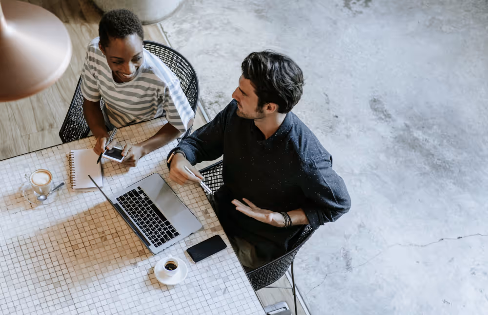Two people discussing work over a laptop