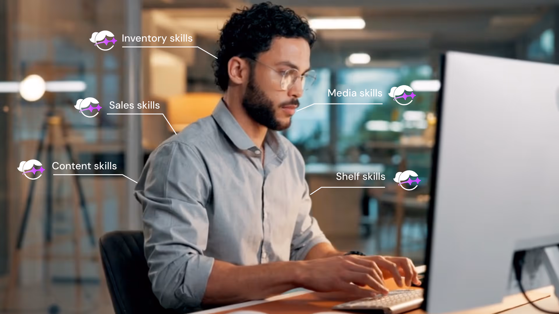 Man with glasses typing on keyboard at desk with labels showing inventory, sales, content, media, and shelf skills.